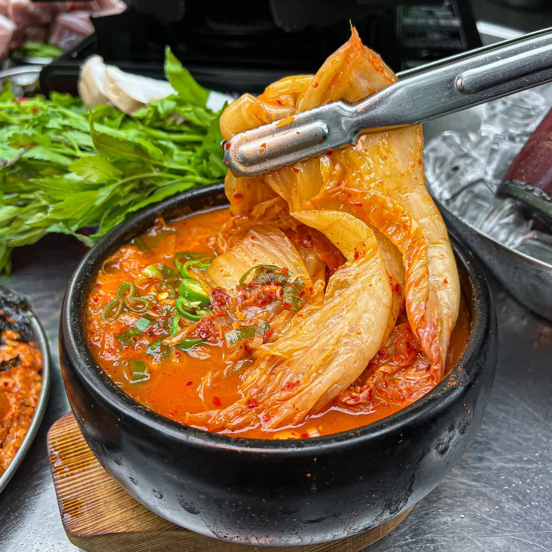 집게로 김치를 들어 올린 한돈 김치찌개 · 이태원 맛집 · Itaewon Korean BBQ