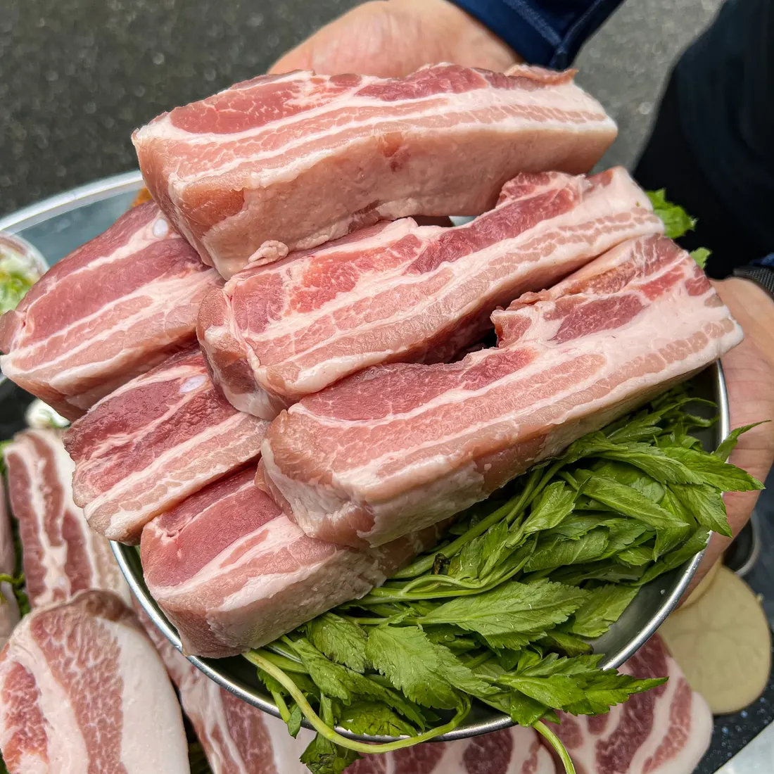 Thick-cut aged pork belly stacked over fresh minari · 이태원 고기집 · Itaewon Restaurants