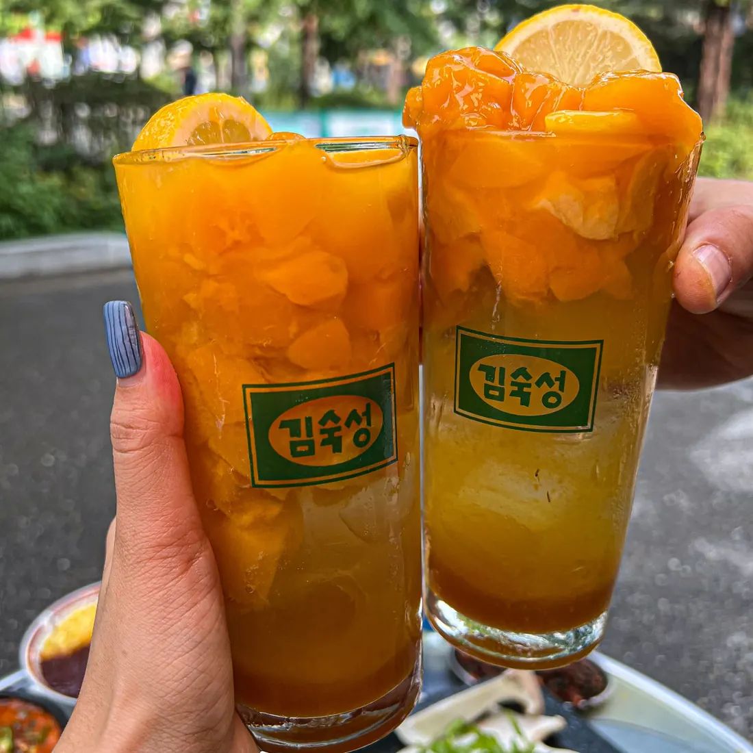Two fruit drinks served in glasses stamped with the Kim Sukseong logo · 이태원 맛집 · Itaewon Korean BBQ